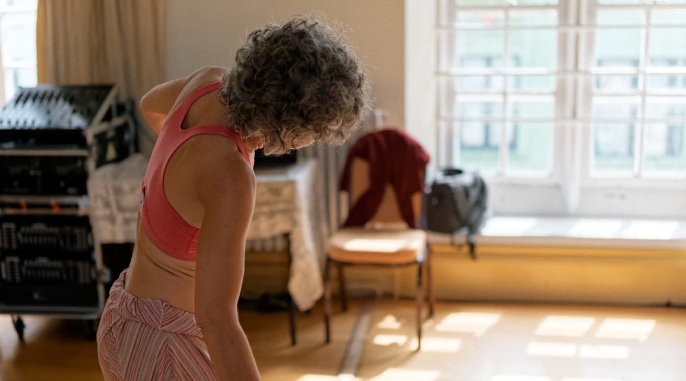 A woman in her fifties training at home in a sunlit room